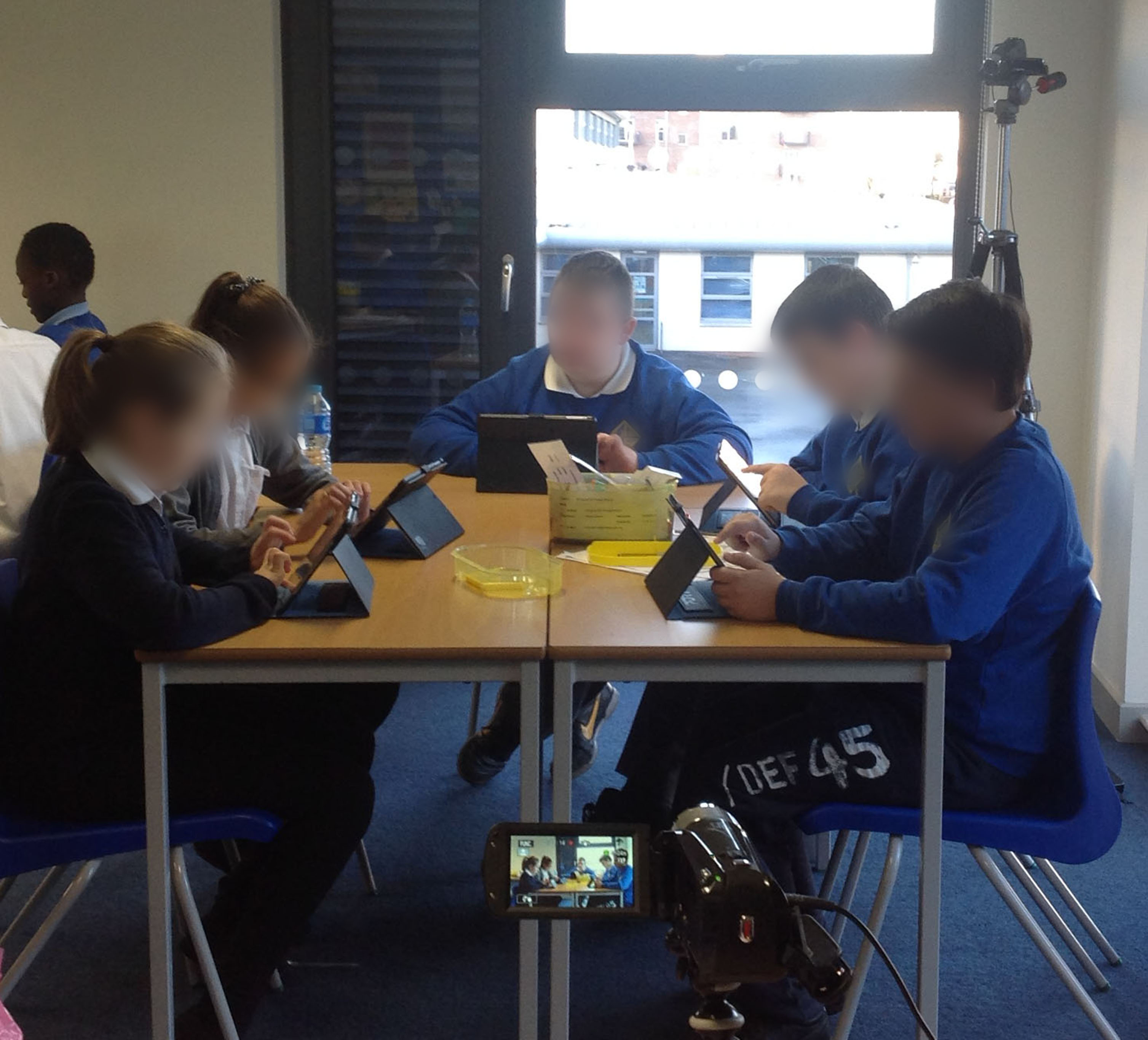 Children sitting at a desk using their iPads